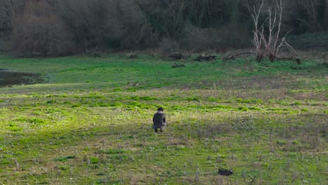 Fotógrafo-Masculino-Tomando-Fotos-De-La-Naturaleza-En-La-Orilla-Del-Lago-Mientras-Está-Sentado-En-El-Campo