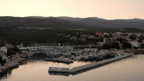 Panoramic-view-of-a-harbour,-golden-hour,-Balkans,-Croatia-coastline,-Adriatic-Sea,-sailboats,-yachts,-calm-waters,-mountains,-sunrise-view-of-a-rocky-coastline,-quiet-morning,-car-road-by-the-sea