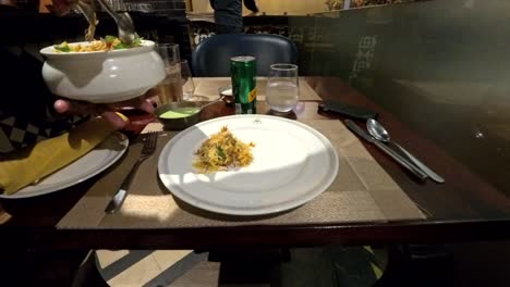 Un-Camarero-Del-Sudeste-Asiático-Sirviendo-Pollo-Dum-Biryani-En-Un-Plato-En-El-Restaurante-Grill-Punjab-En-Cyberhub,-Gurgaon.