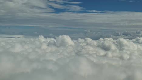 Una-Vista-Espectacular-Desde-La-Ventana-Del-Avión-Con-Nubes-Pasando-Y-Cielos-Azules