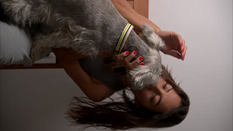 Cámara-Lenta-Vertical-De-Una-Modelo-Morena-Latina-Con-Hermosos-Ojos-Jugando-Con-Su-Perro-Schnauzer