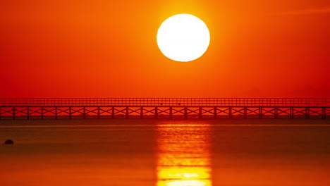 Up-close-sunrise-time-lapse-at-the-beach-sea-sun-reflexion-orange-sky