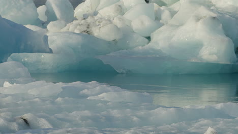 Glacier-Lagoon,-Jökulsárlón,-Iceland,-with-icebergs-and-flowing-icy-blue-water