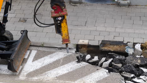 High-angle-static-shot-of-hydraulic-breaker-breaking-asphalt
