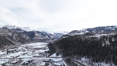 Drone-pull-back-from-resort-town-in-mountain-valley