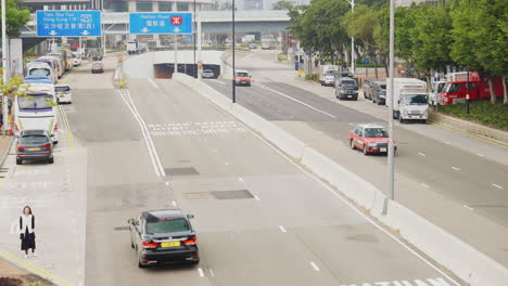 Visuelle-Reise-Durch-Eine-Hongkonger-Allee:-Autos,-Schilder-Und-Die-Stadtlandschaft