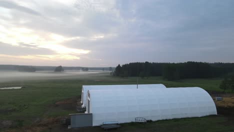 Zwei-Weiße-Gewölbte-Halle-In-Der-Morgendämmerung-Sonnenaufgang-Antenne-Zirkulierende-Links