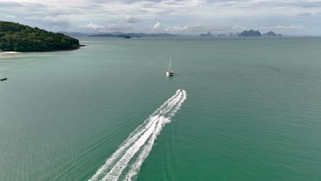 Luftaufnahme---Yacht-Segelt-Durch-Das-Türkisfarbene-Wasser-Der-Insel-Lawa,-Thailand,-Mit-Einer-üppigen-Küste-Und-Entfernten-Inseln-Im-Hintergrund,-Ideal-Für-Reise--Und-Freizeitthemen