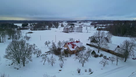 Casa-De-Campo-Rodeada-De-Nieve-Invernal-Caída-Desde-Un-Disparo-Aéreo-Con-Drones