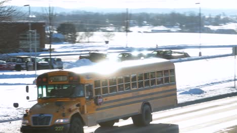 Yellow-school-buses-driving-in-America-during-snowy-winter-day