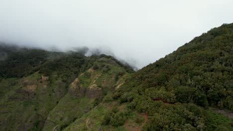 Aerial-View-Over-A-Green-Mountain-Range-Surrounded-By-A-Thick-Layer-Of-Clouds,-La-Gomera,-Spain