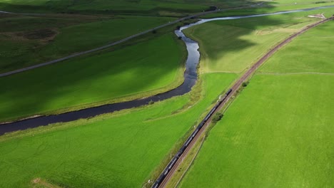 Train-Runs-Alongside-River-Through-Picturesque-Countryside