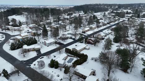 Aerial-flyover-of-modern-suburb-in-the-United-States,-Neighborhood-housing-complex-with-snow-on-ground