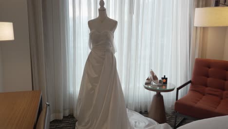 Long-white-wedding-dress-on-a-mannequin-during-preparation-in-hotel-room