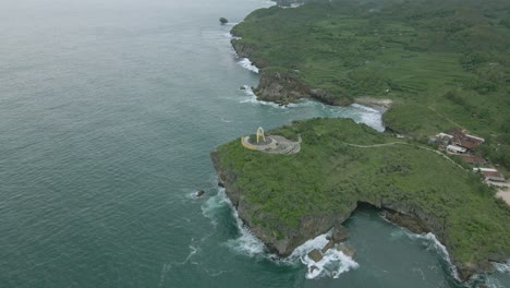 Landmark-fish-monument-on-coastline-of-Indonesia,-aerial-drone-orbit-view