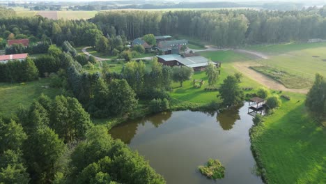 Luftaufnahme-Auf-Bauernhof-In-Polen-Mit-Hochzeitssaal-See-Wald-Baum-Sonnig
