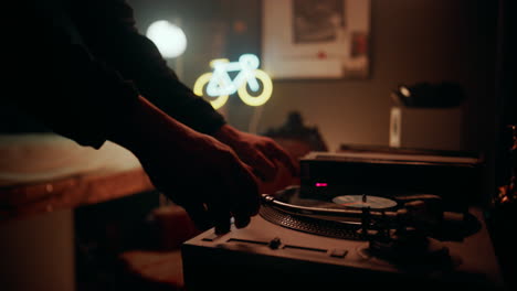 Bike-enthusiast-setting-putting-vinyl-on-his-old-record-player-and-setting-down-the-needle-in-his-home-HIFI-setup