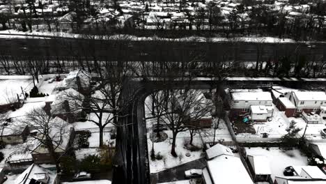 An-aerial-view-of-a-quiet,-suburban-neighborhood-after-a-snowstorm