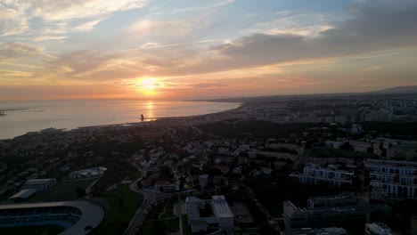 Drohnenansicht-Der-Skyline-Von-Lissabon-Am-Meer-Bei-Sonnenuntergang