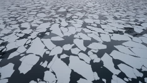 Slow-motion-POV-of-a-winter-ferry-boat-ride-in-Geirangerfjord-to-Geiranger,-Norway,-showcasing-ice-floating-from-mountains-in-the-fjord