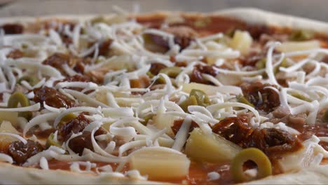 Pizza-Mit-Geriebenem-Käse-Fällt-Auf-Nahaufnahme