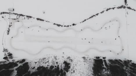 Hohe-Luftaufnahme-Von-Oben-Nach-Unten-Auf-Die-Schneebedeckte-Drift-Event-Rennstrecke-Mit-Vollem-Kreis-Und-Kurven