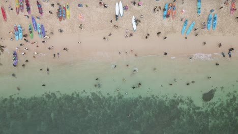People-enjoys-Sadranan-beach-in-Indonesia,-aerial-drone-view