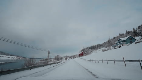 POV-drive-through-Norway's-western-fjord-on-a-snowy-winter-day,-featuring-beautiful-snowy-mountains-and-roads