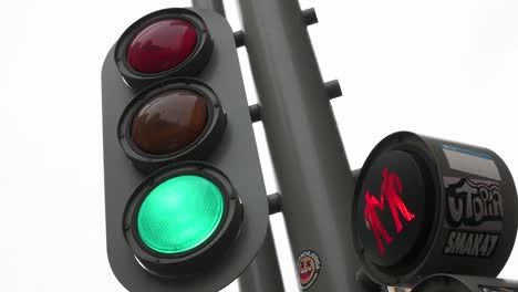 City-traffic-light-adorned-with-stickers-is-seen-changing-from-green-to-red-for-vehicles-and-vice-versa-for-pedestrians