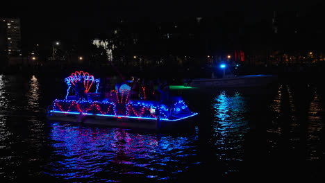 Decorated-Lighted-Motorboat-And-Police-Boat-Navigating-By-Night-At-Tampa-Christmas-Boat-Parade,-Florida