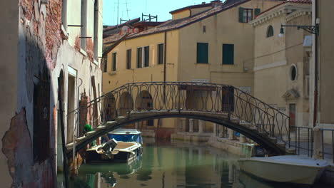 In-the-heart-of-Venice,-Italy,-a-bridge-spans-a-quaint-canal-in-a-neighborhood