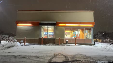 Snowy-Dunkin-store-in-the-evening-while-snowing