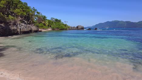Pov-walk-at-sandy-beach-into-clear-water-of-bay-in-Samana-during-sunny-day-with-blue-sky