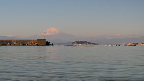 Toma-Panorámica-Sobre-El-Océano-Con-El-Monte-Fuji-Y-La-Isla-Enoshima-Al-Fondo.