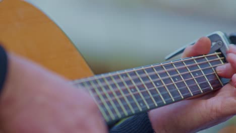 Guitarist-plays-on-acoustic-guitar,-closeup-view-of-hands-wrists,-fingers,-frets-and-strings