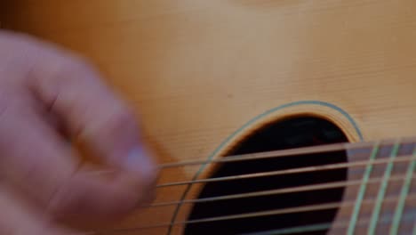 acoustic-guitar-playing,-closeup-view-of-a-hand-wrist,-fingers-and-strings