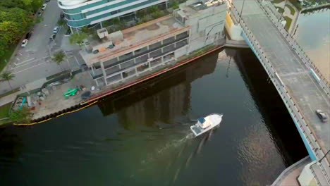Aerial-shot-of-boat-going-under-a-bridge-in-Miami