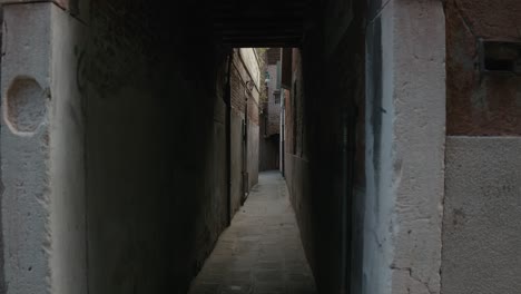 Narrow-alleyway-in-Venice-shadows,-Italy