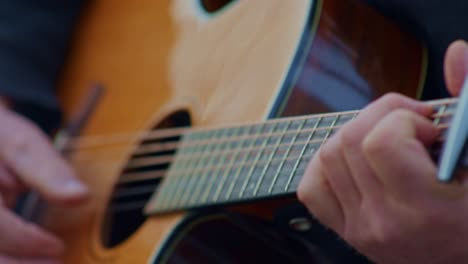 Guitarist-plays-etude-on-acoustic-guitar,-closeup-view-of-hands-wrists,-fingers,-frets-and-strings