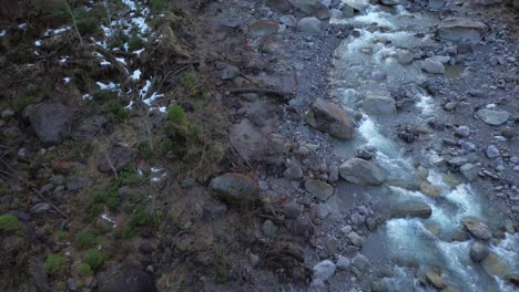 Vuelo-De-Drones-Sobre-El-Río-De-Montaña-En-Primavera-Con-Algo-De-Nieve-Restante