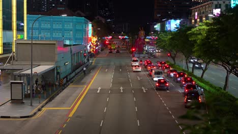 Night-timelapse-shot-capturing-busy-traffic-motions-on-New-bridge-road-with-dragon-display-at-public-art-installation-during-Chinese-new-year,-downtown-Singapore