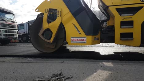 New-Asphalt-Road-Pavement,-Close-Up-of-Roller-Machine-on-Construction-Site