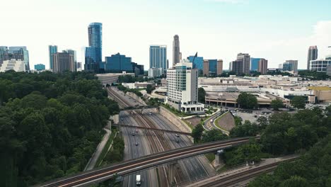 Drohnenaufnahme-Des-Verkehrs-Auf-Der-Autobahn-Mit-Der-Skyline-Von-Atlanta-Im-Hintergrund