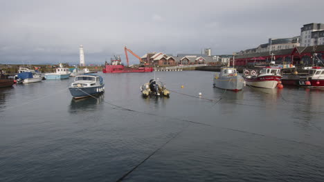 Boats-in-Newhaven-Harbour-at-high-tide-on-an-overcast-day-in-Edinburgh,-Scotland,-UK