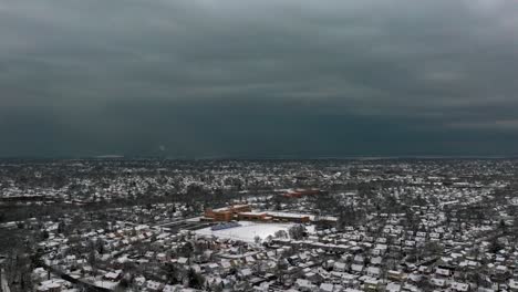 An-aerial-view-of-a-suburban-neighborhood-on-Long-Island,-NY-on-a-cloudy-winter-day-with-snow-on-the-ground