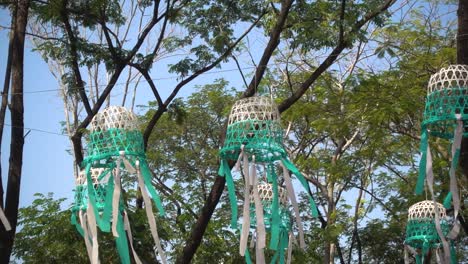 Beautiful-handicraft-lanterns-waving-against-trees-and-sky