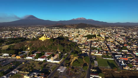 Aerial-view-overlooking-the-cityscape-of-Cholula,-golden-hour-in-Puebla,-Mexico
