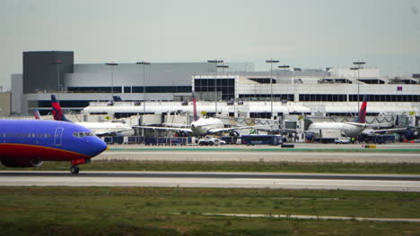 Time-lapse-of-plane-and-traffic-at-a-airport,-cloudy-day-in-Los-Angeles,-USA