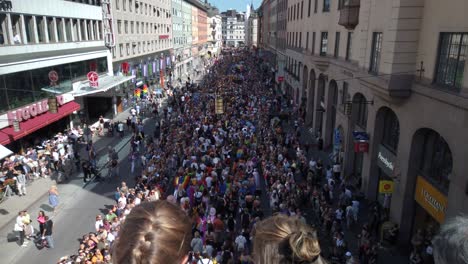 People-marching-in-the-Stockholm-Pride-Parade,-seen-from-above-and-behind