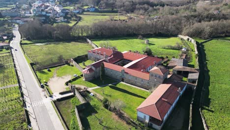 Wide-angle-orbit-around-rectangular-buildings-of-monastery-off-rural-country-road-in-Spain